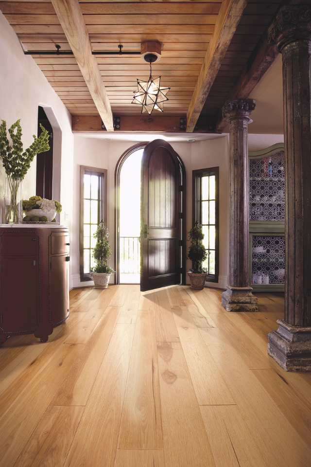 hickory hardwood in entryway of vintage revival home with statement lighting and wood beamed ceiling